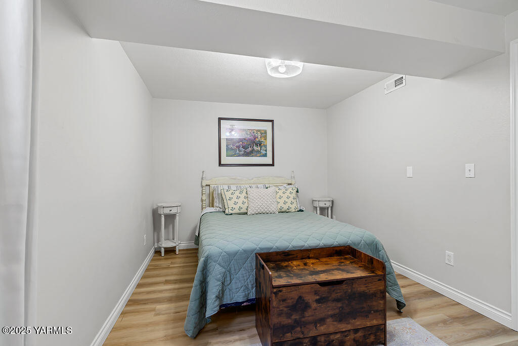 11809 Occidental Road Yakima, WA 98908 - Photo 44 of 60 a bedroom with a bed and a lamp on dresser