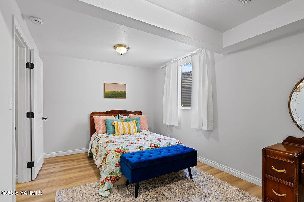 11809 Occidental Road Yakima, WA 98908 - Photo 45 of 60 a bedroom with a bed a dresser and a window