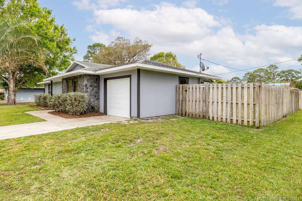 6803 Salerno Road Fort Pierce, FL 34951 - Photo 19 of 65 a backyard of a house with plants and wooden fence