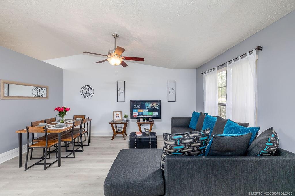 6803 Salerno Road Fort Pierce, FL 34951 - Photo 23 of 65 a living room with furniture and a fireplace