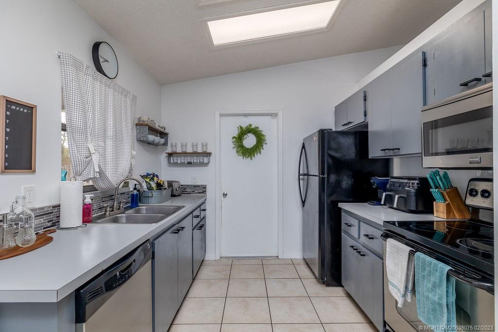 6803 Salerno Road Fort Pierce, FL 34951 - Photo 29 of 65 a kitchen with stainless steel appliances a sink stove refrigerator and cabinets