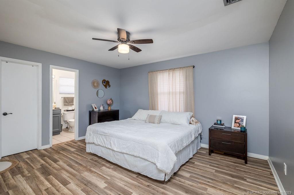 6803 Salerno Road Fort Pierce, FL 34951 - Photo 42 of 65 a bedroom with a bed and a chandelier