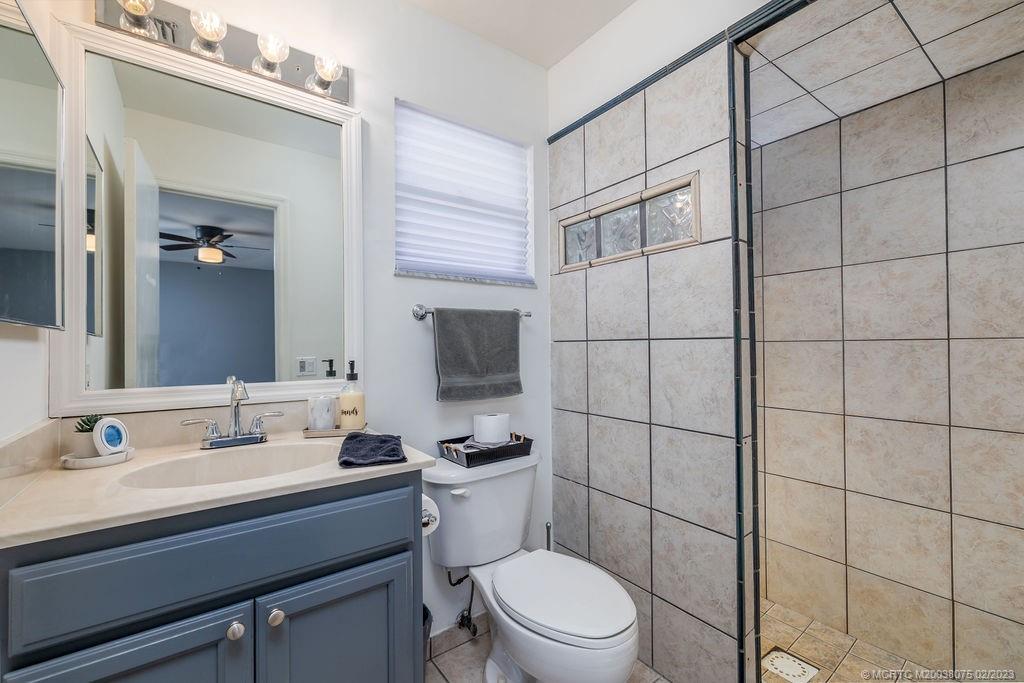 6803 Salerno Road Fort Pierce, FL 34951 - Photo 45 of 65 a bathroom with a toilet a sink and mirror