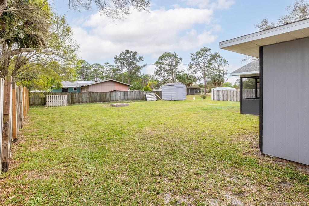 6803 Salerno Road Fort Pierce, FL 34951 - Photo 6 of 65 a view of a patio with a table and chairs under an umbrella