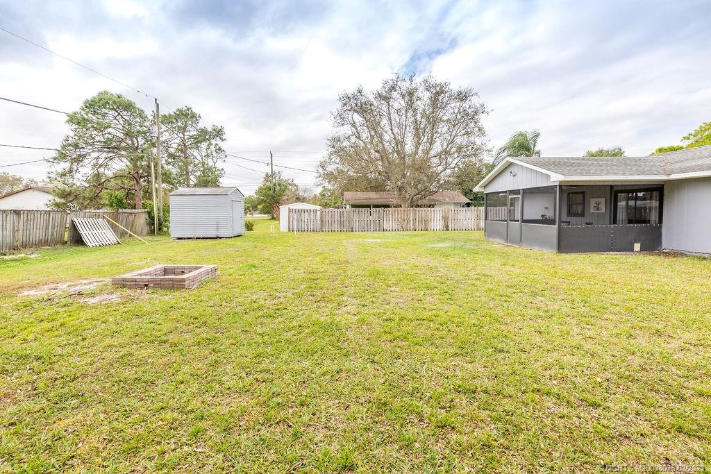6803 Salerno Road Fort Pierce, FL 34951 - Photo 7 of 65 a view of a house with a swimming pool and a yard