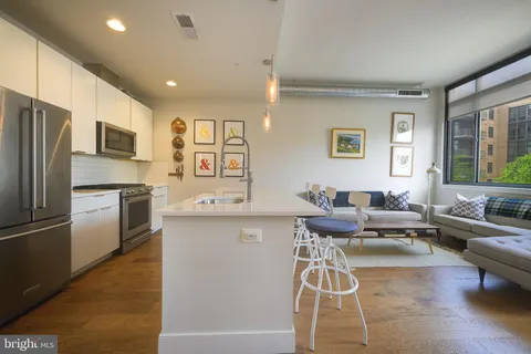 a living room with furniture and kitchen view