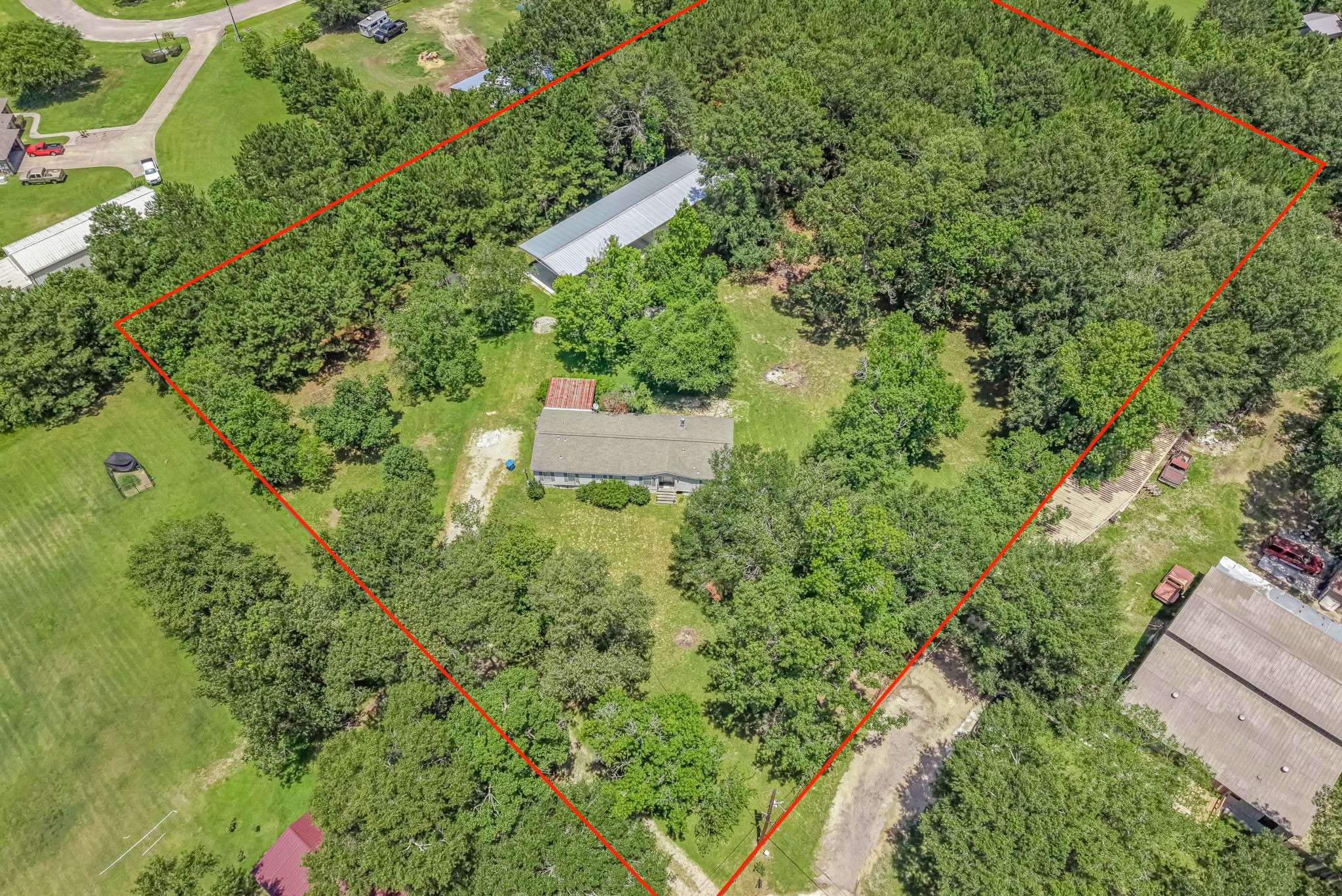 25979 Shade Tree Lane Splendora, TX 77372 - Photo 2 of 22 Combining functionality with endless potential, this 2.996 acres property features a current manufactured home and a remarkable metal building, providing exceptional space for all your needs.