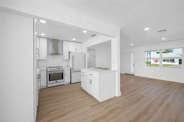 a kitchen with a refrigerator a stove and a cabinets