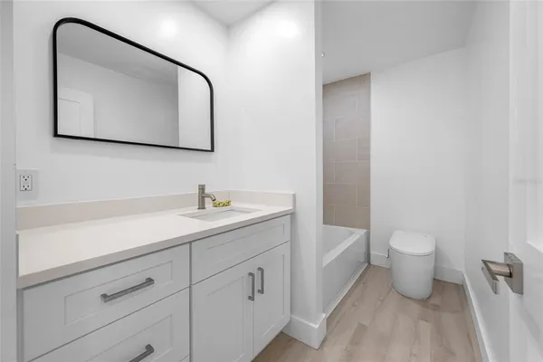 a view of a hallway with wooden floor and closet area