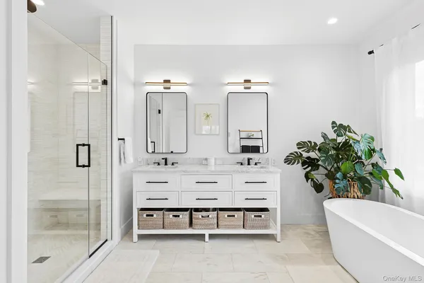 a bathroom with a bathtub a sink and a potted plant