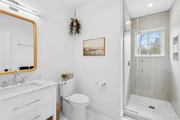a bathroom with a granite countertop sink toilet and shower
