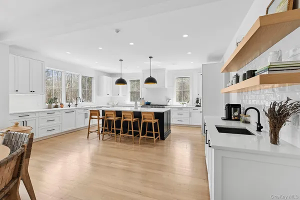 a kitchen with kitchen island granite countertop a sink and cabinets