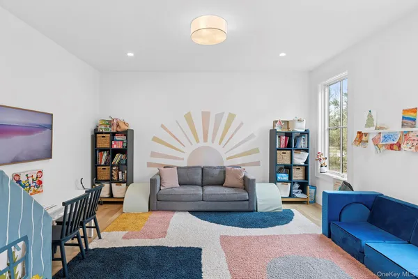 a living room with furniture and a bookshelf with wooden floor