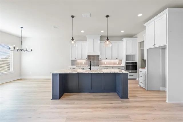 a large kitchen with stainless steel appliances kitchen island granite countertop a refrigerator a stove and a sink