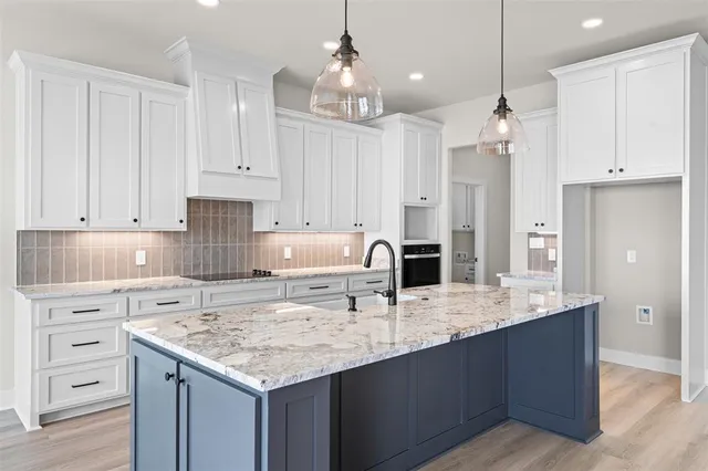a kitchen with kitchen island granite countertop a sink center island a counter space and cabinets