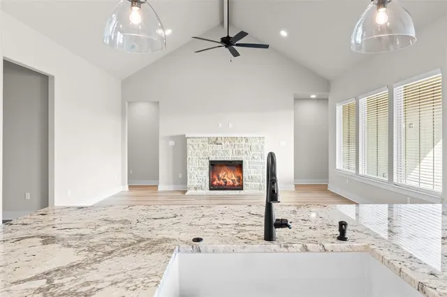 a kitchen with granite countertop a stove sink and cabinets