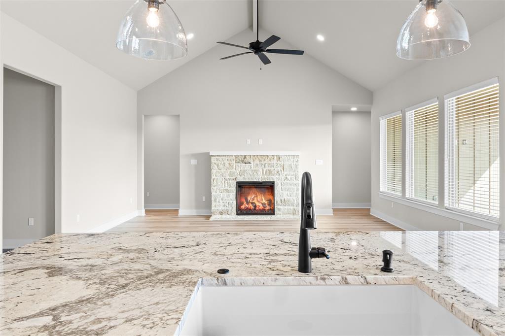 900 Day Star Drive Hewitt, TX 76643 - Photo 19 of 40 Unfurnished living room with a stone fireplace, beam ceiling, high vaulted ceiling, ceiling fan, and light wood-style flooring