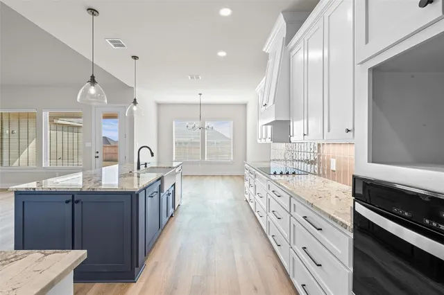 a kitchen with granite countertop a sink stove and cabinets