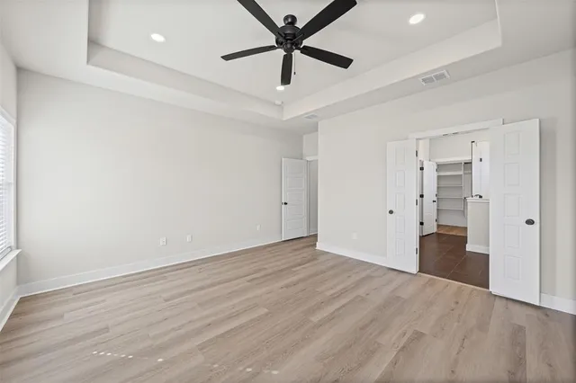 an empty room with closet and a ceiling fan