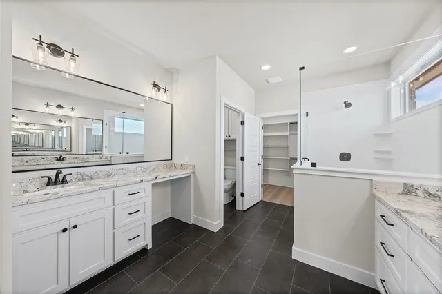 a large kitchen with cabinets a sink dishwasher a refrigerator and white cabinets