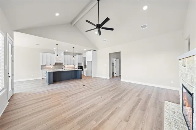 a view of a kitchen with kitchen island a sink stainless steel appliances and cabinets