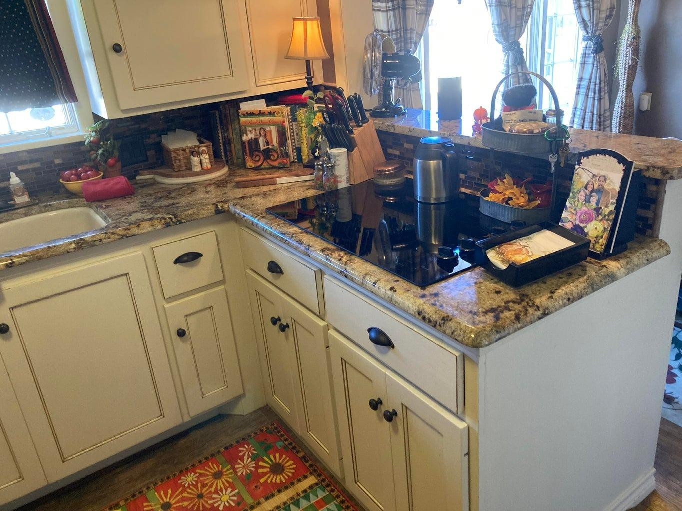 715 Denver Plainview, TX 79072 - Photo 17 of 45 a kitchen with granite countertop a sink a stove and cabinets
