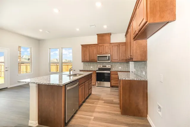 a kitchen with stainless steel appliances granite countertop a sink stove and refrigerator