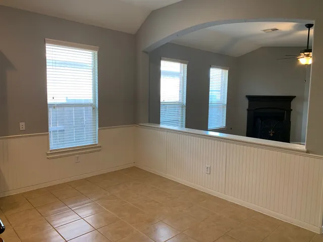 a view of an empty room with window and bathroom