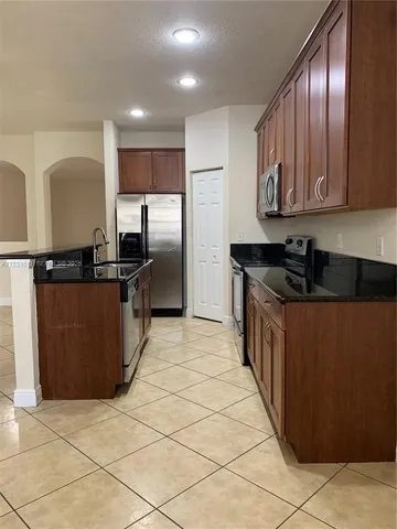 a kitchen with stainless steel appliances a refrigerator sink and cabinets