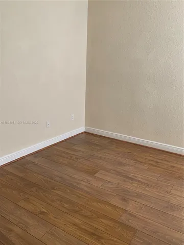 an empty room with wooden floor and a window