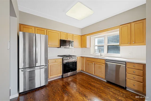 a kitchen with granite countertop stainless steel appliances a sink cabinets and a window