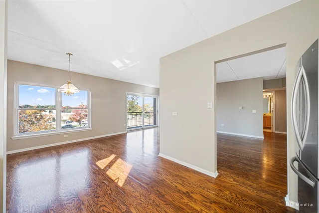 an empty room with wooden floor and a window