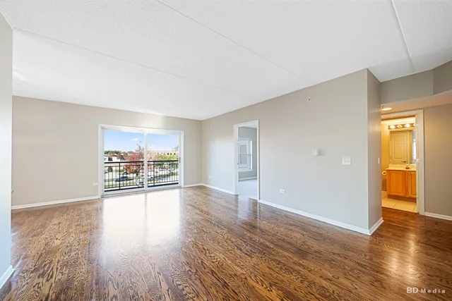 a view of a big room with wooden floor and windows