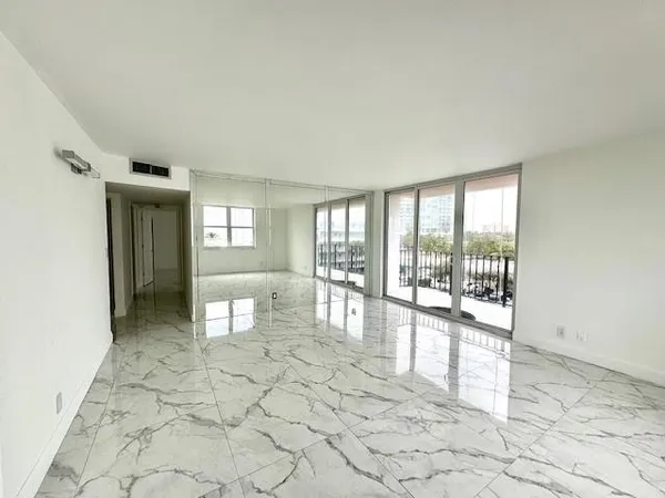 a kitchen with stainless steel appliances granite countertop a sink a stove and white cabinets with wooden floor