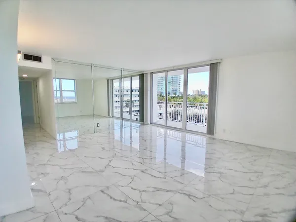 a view of a big room with windows and chandelier