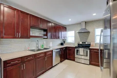 a kitchen with stainless steel appliances granite countertop wooden cabinets a stove a sink and a microwave