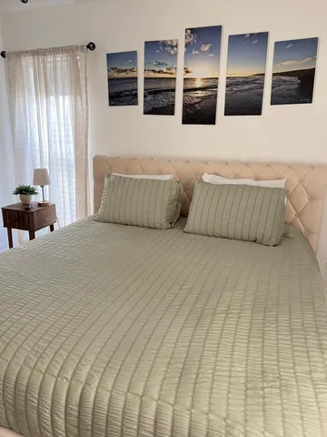 a bedroom with a large bed and a flat tv screen