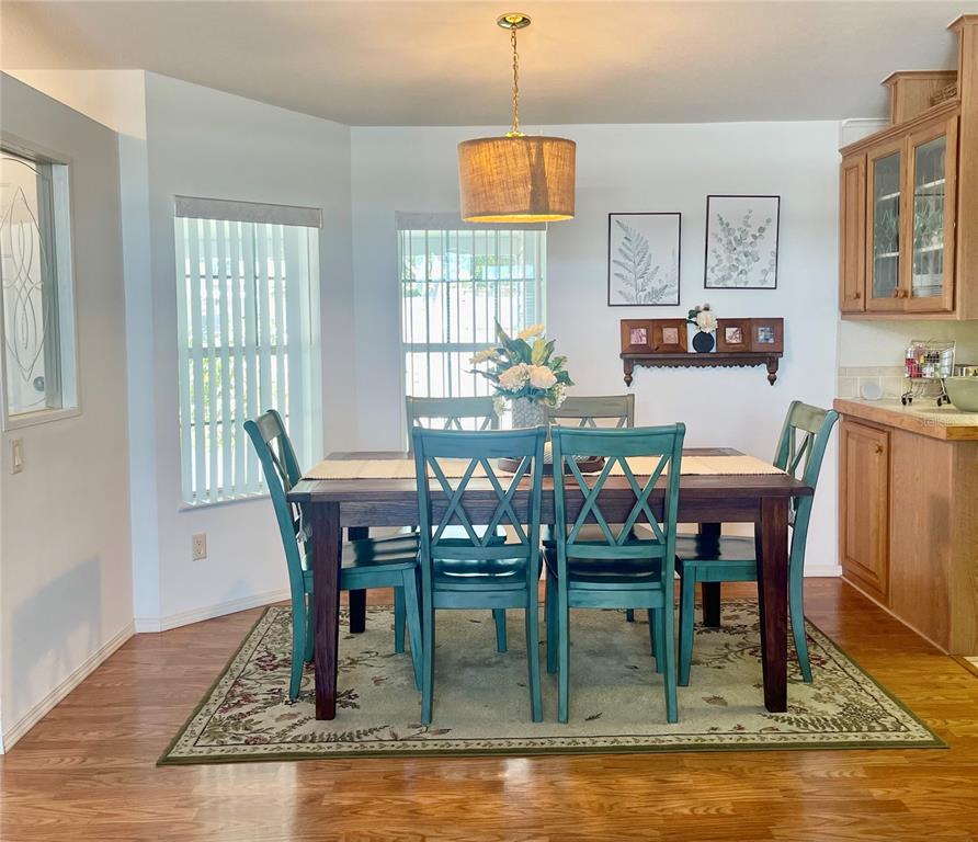 11200 Walsingham Road, Unit 139 Largo, FL 33778 - Photo 5 of 13 a dining room with furniture a rug and a floor to ceiling window