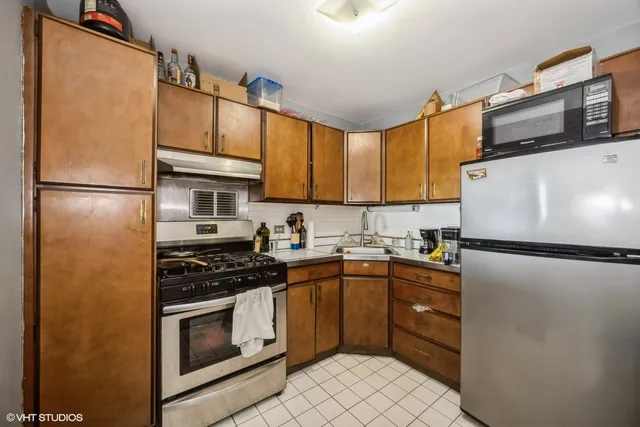 a kitchen with stainless steel appliances granite countertop a refrigerator sink stove and microwave