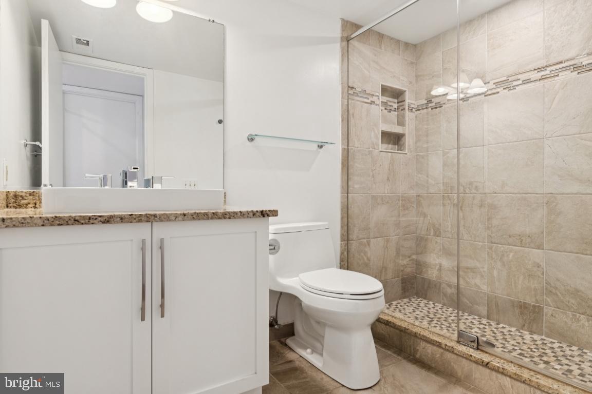 2102 South Road Baltimore, MD 21209 - Photo 29 of 37 a bathroom with a granite countertop sink a toilet and shower
