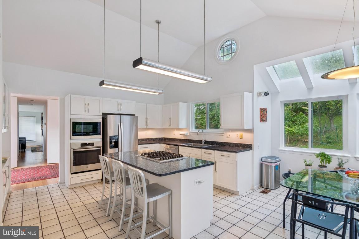 2102 South Road Baltimore, MD 21209 - Photo 9 of 37 a kitchen with stainless steel appliances kitchen island granite countertop a stove a sink and a refrigerator