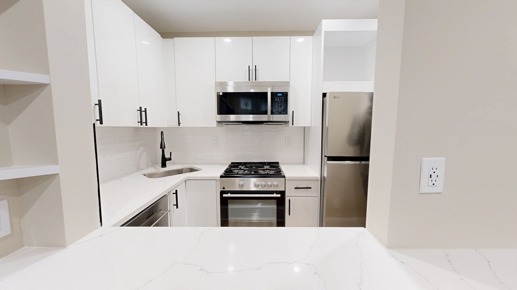 41 Edgerly Road, Unit 1 Boston, MA 02115 - Photo 9 of 12 a kitchen with a stove sink and refrigerator