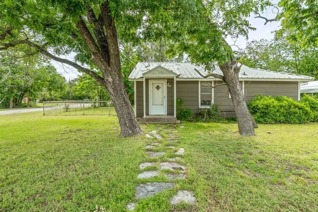a front view of a house with yard and green space