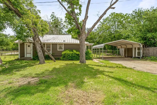 a view of a house with a tree and a yard