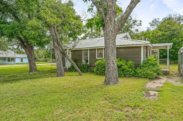 a front view of a house with yard and green space