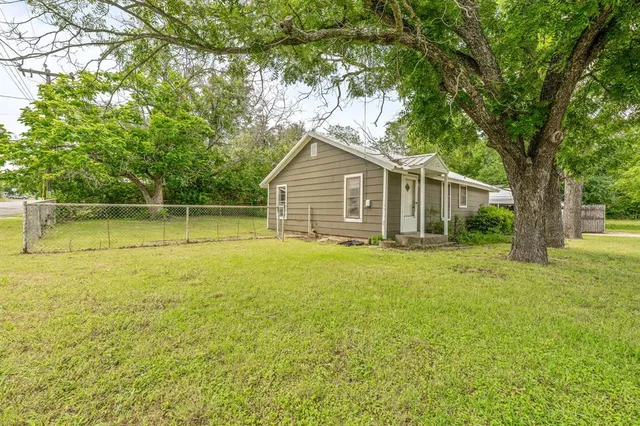 a view of a house with a backyard and a tree