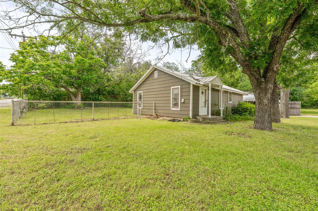 400 South Pecan Street Hamilton, TX 76531 - Photo 2 of 19 a view of a house with a backyard and a tree