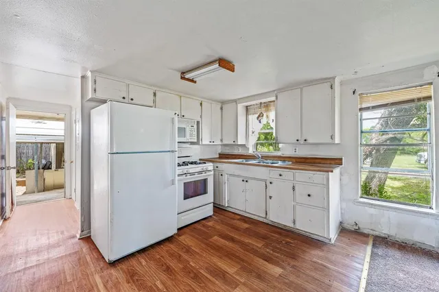a kitchen with stainless steel appliances a refrigerator sink and white cabinets
