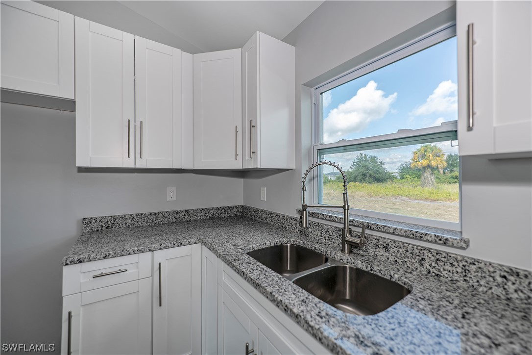 9024 Largo Circle LaBelle, FL 33935 - Photo 14 of 27 a kitchen with granite countertop a sink and a window