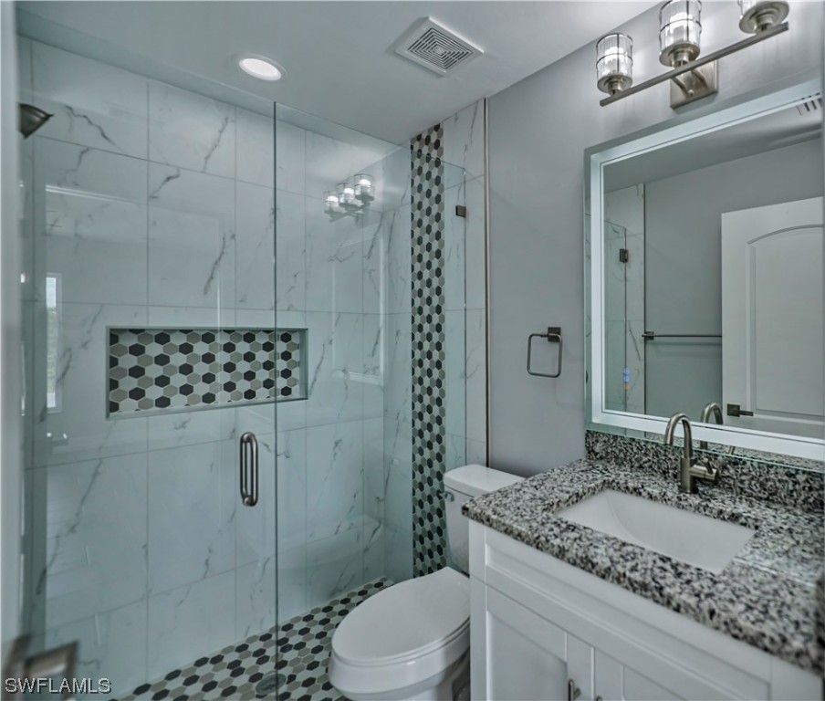 9024 Largo Circle LaBelle, FL 33935 - Photo 19 of 27 a bathroom with a granite countertop sink a toilet a mirror and shower